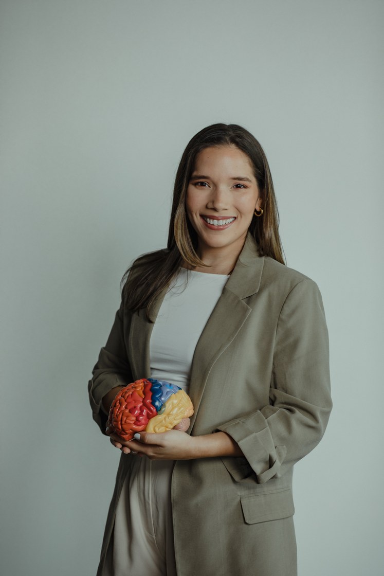 Natalia López Neuropsicóloga sosteniendo modelo anatómico del cerebro